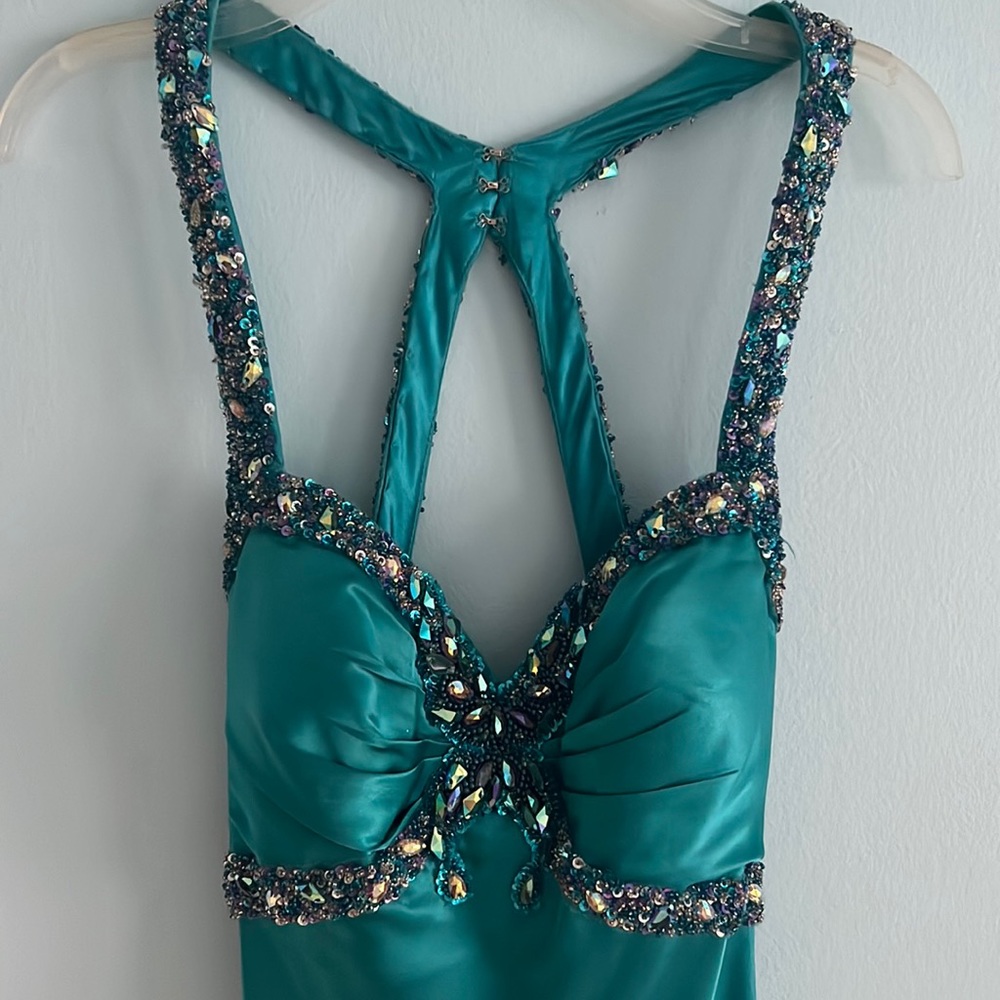 Mermaid style gown with pleated train. Purple, clear, and blue beads on dress.